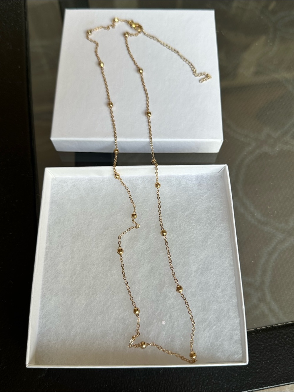 Delicate gold-tone satellite-style chain necklace featuring spherical beads.